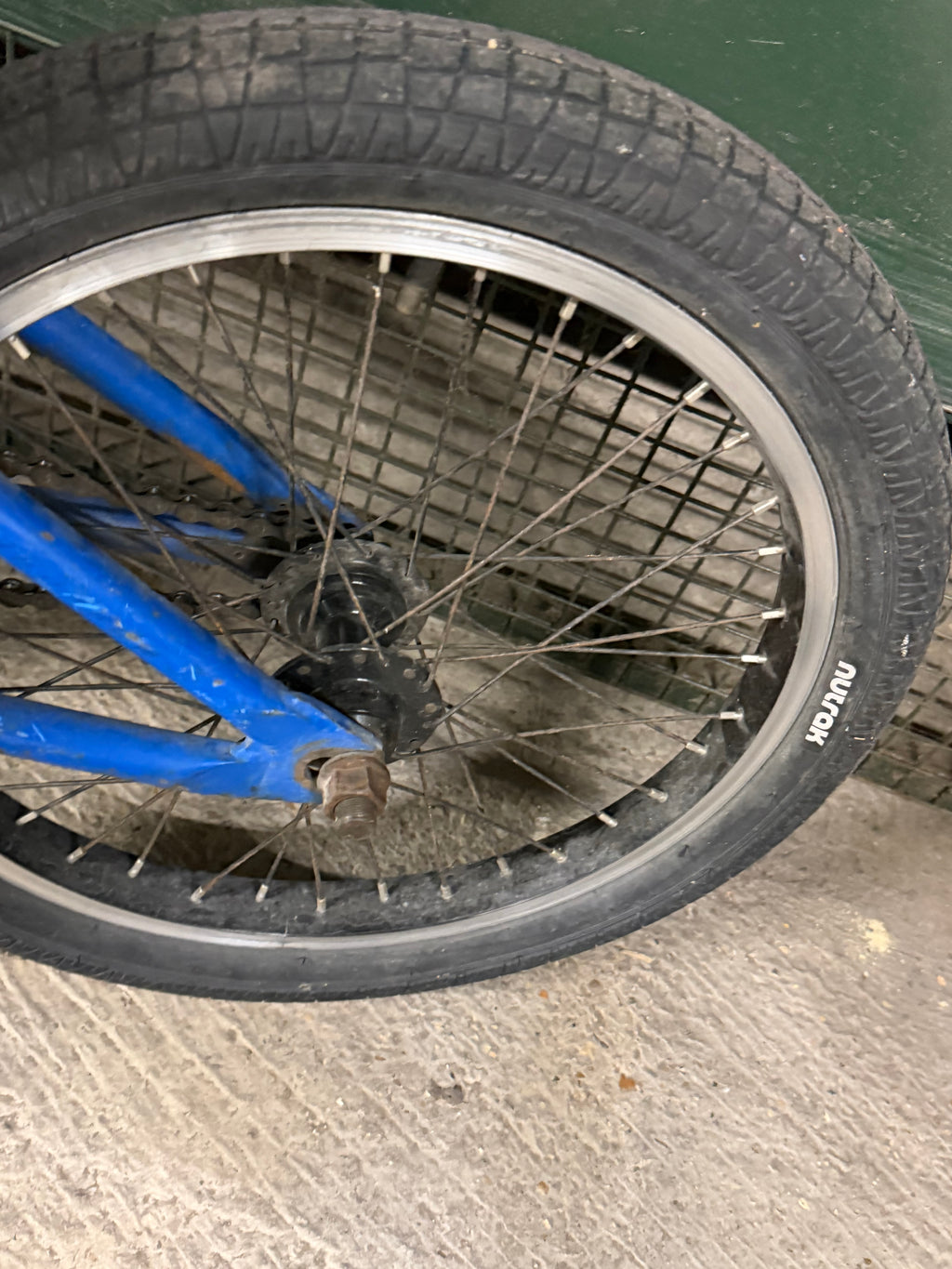 Rear wheel and tyre of blue kids' BMX bike
