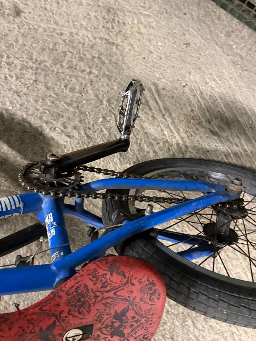 Crank, pedal and red saddle on blue Sunday BMX