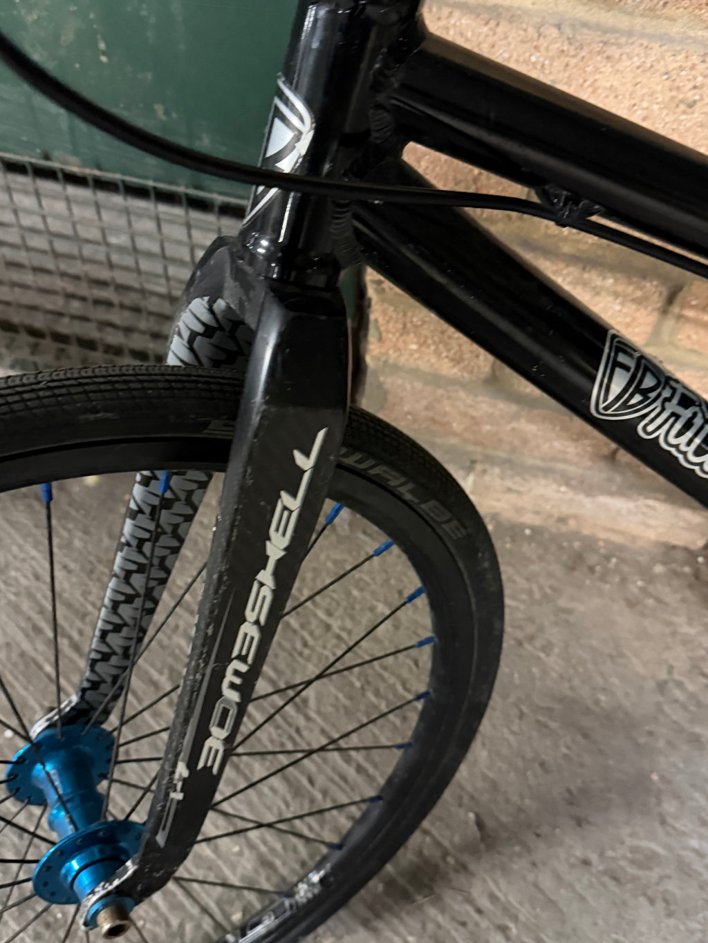 Front wheel, blue hub and carbon fork of kids' BMX