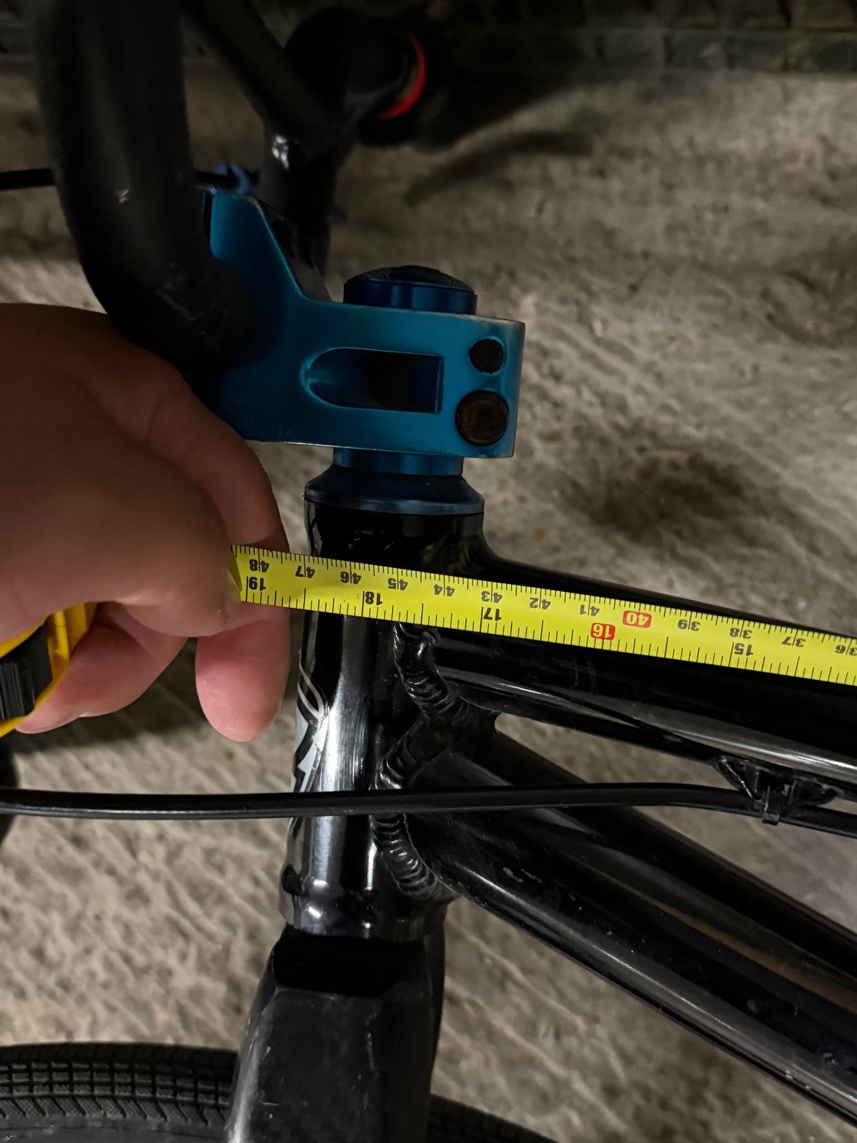 Tape measure beside BMX head tube and blue stem