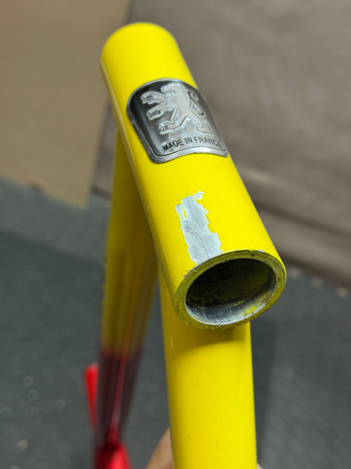 Custom red and yellow aluminium track frame – head tube close-up showing damaged area