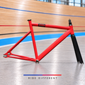 State red aluminium track frameset – side view with carbon fork on velodrome background